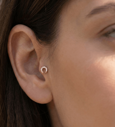 Tragus piercing guld